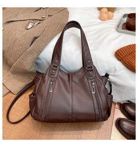 Macro shot of large dark brown tote bag showing retro lychee texture and zipper detail