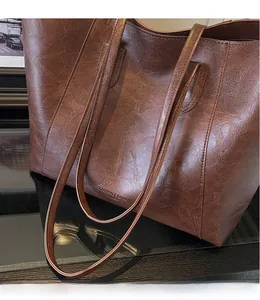 Detailed macro view of vintage brown leather texture and embossed fashion text on tote bag