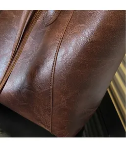 Macro shot of retro brown leather texture and reinforced double-stitching on the tote bag