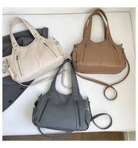 Flat lay of large tote bags in cream, brown and gray with pebbled leather texture