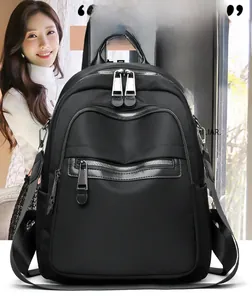 Detailed view of black nylon backpack with multiple silver metal zipper compartments