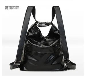 Back view of black shiny faux leather backpack with wide straps and metal hardware detail