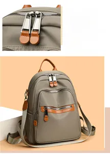 Detail of khaki nylon backpack featuring durable double zippers and stylish leather handles