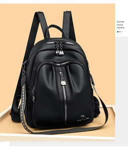 Detail view of black lychee grain PU leather backpack with silver zippers and kangaroo logo