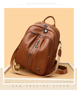 Detail of brown litchi pattern PU leather backpack with kangaroo logo and ethnic strap