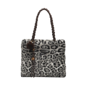 Sac cabas tendance en peluche léopard avec anses tressées brunes et pompon en fourrure