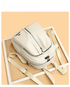 Detailed view of white litchi pattern PU leather backpack with kangaroo metal logo