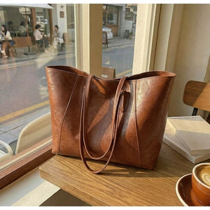 Macro view of vintage brown leather texture and stitching on the large tote bag