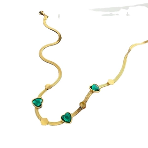 Elegant gold snake chain necklace with three emerald green heart-shaped gemstones