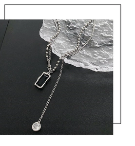 Close-up of double-layer silver necklace featuring a black rectangle and clear round crystal