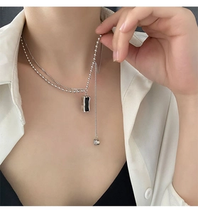 Double-layered necklace with black rectangular pendant and silver bead chain detail