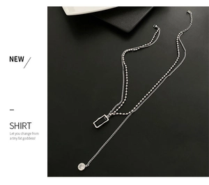 Macro view of minimalist double-layered silver chain with a black rectangular pendant