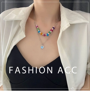 Détail d'un collier à perles superposées avec un pendentif cœur brillant sur modèle