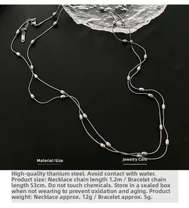 Detailed view of silver titanium steel long chain necklace with oval metal beads