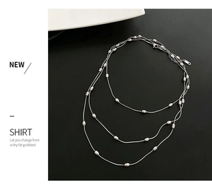 Detailed view of triple-layered silver steel necklace with polished oval bead charms
