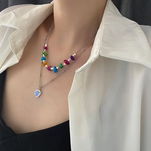 Collier double rang argenté avec perles colorées et pendentif cœur sur un mannequin