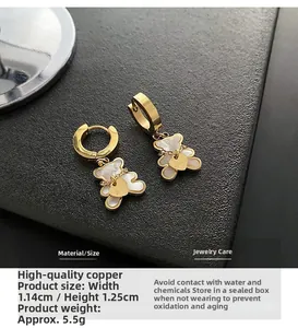 Detailed view of bear earrings with mother of pearl and engraved love heart pendant