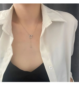 Dettaglio della collana ad anelli argento con pendente a nappa su un modello femminile