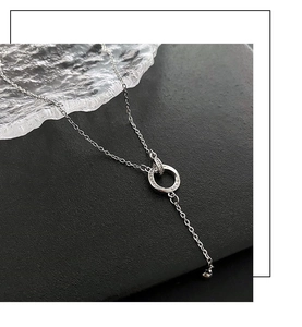Dettaglio di anelli d'argento intrecciati con incisione LOVE e frangia di cristallo