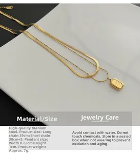 Detailed view of golden double-layer titanium necklace with flat snake chain and rectangular pendant