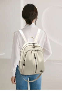 Detail of off-white lychee texture backpack on model showing casual lifestyle style