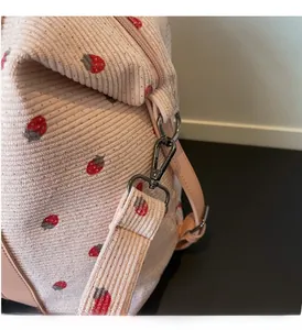 Detail of high-quality dark metallic hook on corduroy bag with strawberry pattern