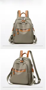 Detailed front and side views of grey nylon backpack with brown leather trim and silver zippers