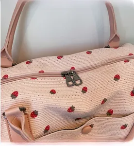 Close-up of dual metal zippers and strawberry pattern on pink corduroy travel bag