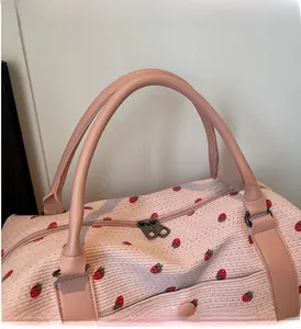 Detail of pink strawberry print bag with sturdy leather handles and metal zipper