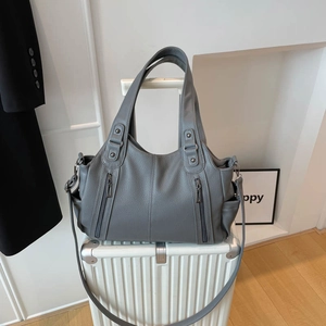 Minimalist grey faux leather tote bag with multiple zip pockets and adjustable strap