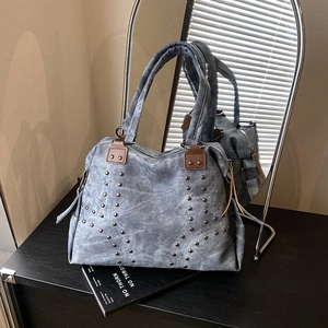 Bohemian retro blue tote bag with silver studs and tassel detail on book background