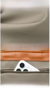 Detail view of khaki nylon backpack showing back anti-theft zipper pocket and texture