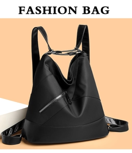 Dettaglio dello zaino nero in nylon con cerniera diagonale e hardware ad anello metallico