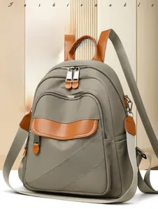 Detailed shot of grey nylon backpack featuring contrast caramel leather trim and pockets