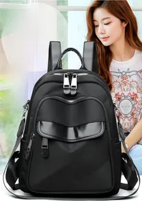 Detail of urban black nylon backpack featuring sleek leather panels and diagonal stitching
