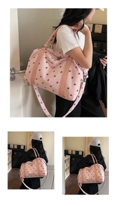 Detailed close-up of pink corduroy travel bag with strawberry print and adjustable strap