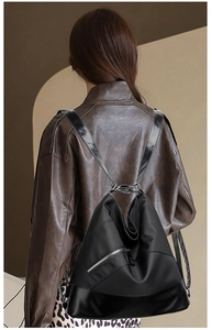 Dettaglio di zaino in nylon impermeabile con cerniera diagonale e base in pelle