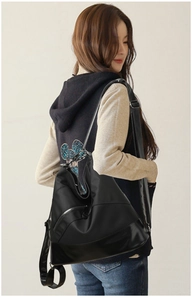 Vista posteriore di una borsa a tracolla in nylon nero con base in pelle e zip metallica