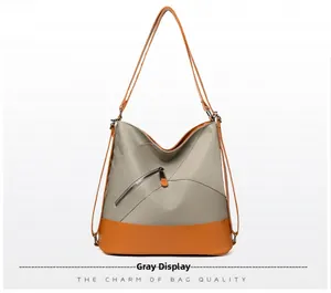 Dettaglio della borsa a tracolla grigia in nylon con finiture in pelle arancione