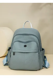 Macro shot of light blue fabric texture and circular logo on a modern backpack