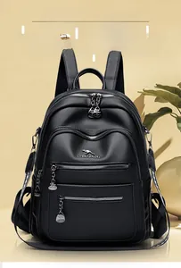 Close-up of litchi texture black leather backpack with kangaroo logo and metal zippers