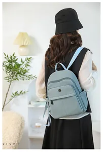 Rear view of a light blue-grey functional backpack with multiple storage compartments