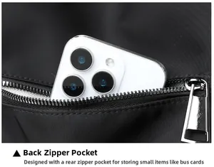 Dettaglio della tasca posteriore antifurto su borsa in nylon nero con uno smartphone