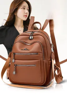 Close-up of brown litchi grain leather backpack with metallic zippers and branding details