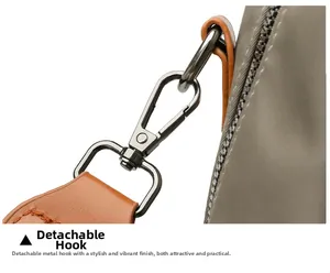 Detail of detachable black metal hook with brown leather strap on taupe fabric bag