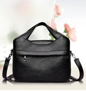 Close-up of black lychee grain leather tote bag with metal ring zipper and shoulder strap