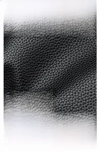 Detailed macro view of black lychee textured leather and polished metal kangaroo logo