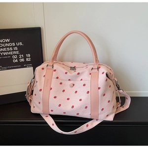 Detailed close-up of pink strawberry print travel bag showing corduroy texture and strap