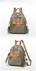 Detail view of khaki nylon backpack featuring waterproof fabric and brown leather accents