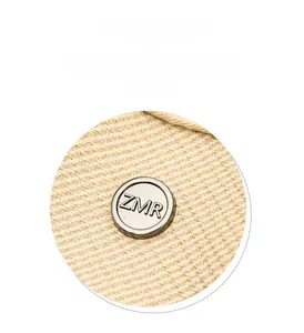 Detailed macro view of the fabric texture and branded silver metal buckle on the beige backpack